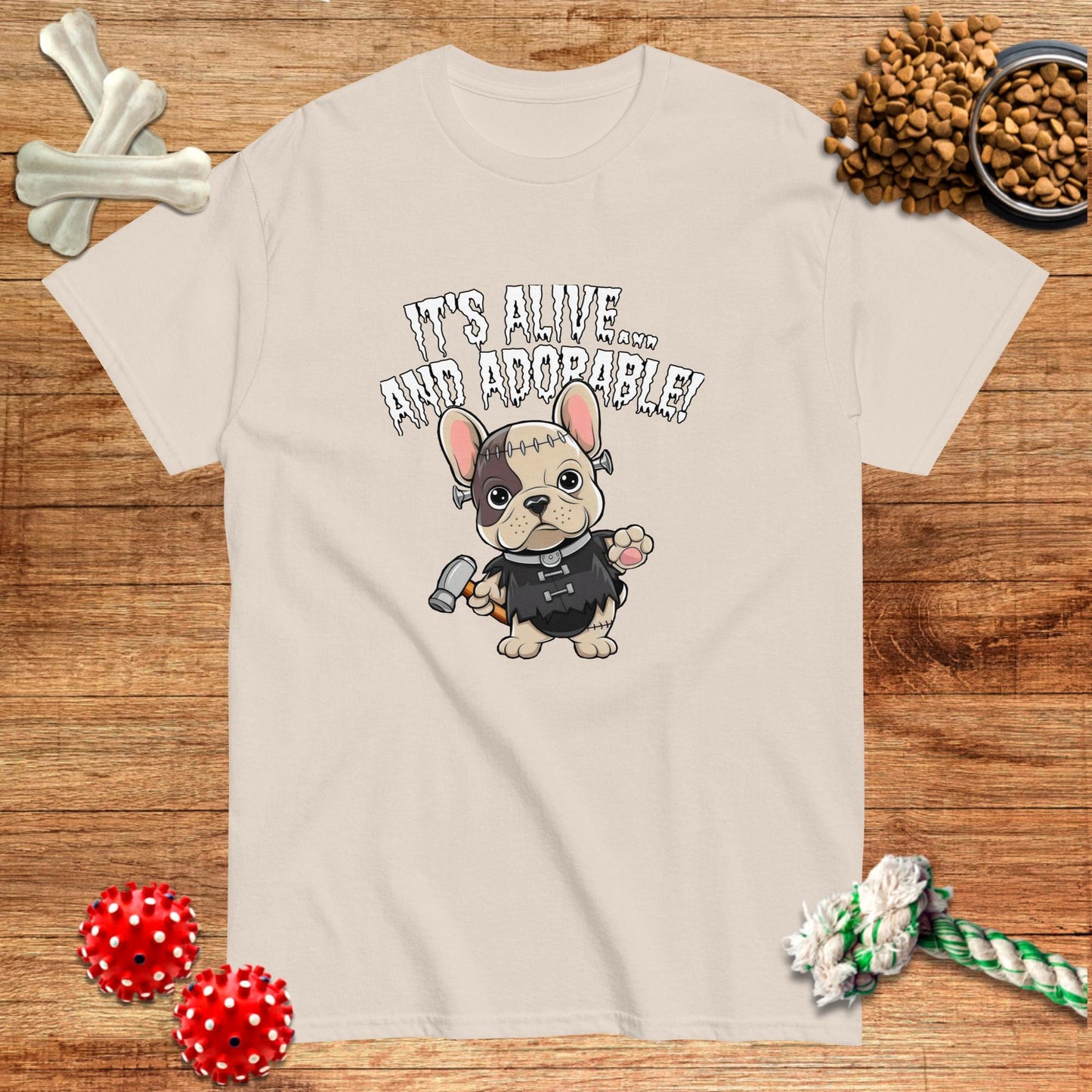 Frenchiestein Halloween T-Shirt featuring a cartoon French Bulldog in a monster costume, light beige color.